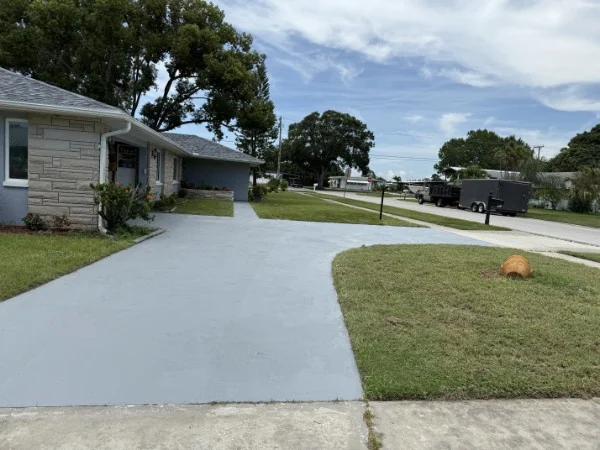 Finished concrete driveway beside a landscaped home