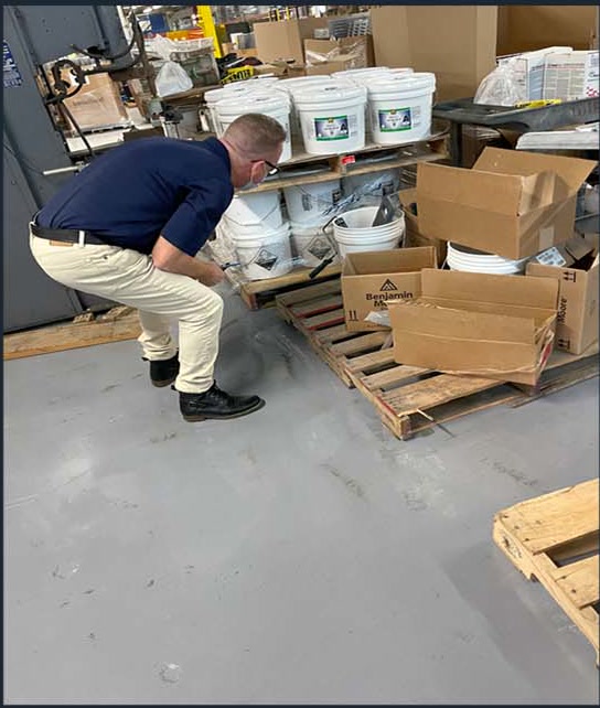 Worker beside stacked floor coating materials