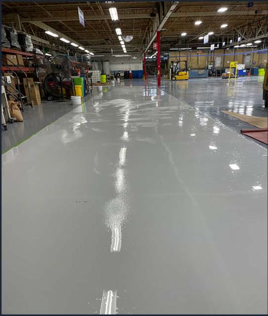 Reflective gray coating across a commercial warehouse floor